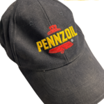 Musta vintage Pennzoil lippis keltaisella ja punaisella brodeerauksella kuvattuna yläviistosta
