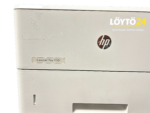Lähikuva HP LaserJet Pro M501dn -tulostimen etupaneelin mallimerkinnästä ja teippijäljistä.